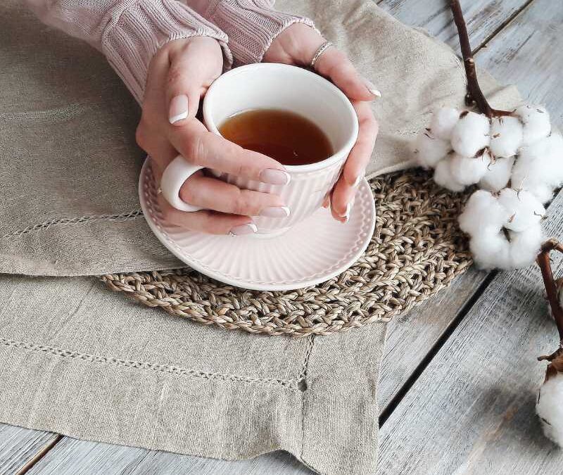 Blog title-Liver Detox Tea: Your Complete Guide. Image is of a woman holding a mug of tea on a placemat.