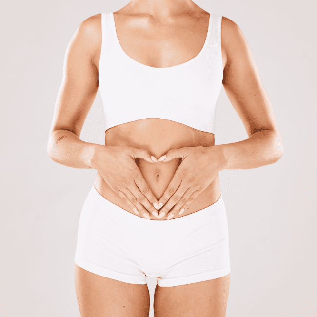 Gut Health 101 Blog Post. Image is of a woman holding her hands in a heart shape over her abdomen.