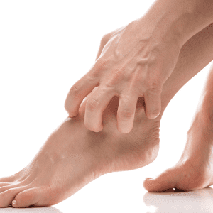 Gut Health 101 Blog Post. Image is of a woman scratching her ankle with bare feet.